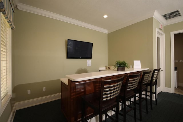 bar with crown molding and dark colored carpet