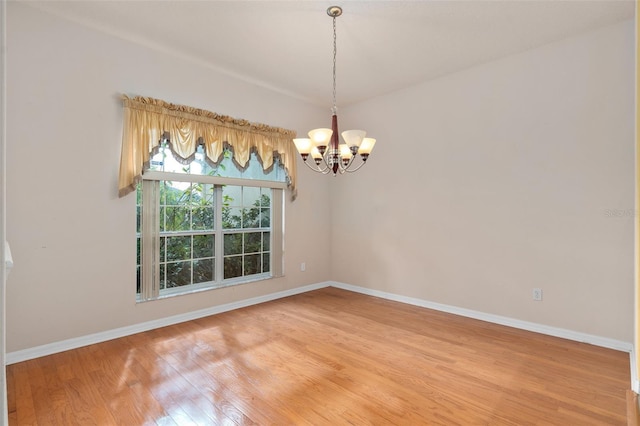 unfurnished room featuring hardwood / wood-style floors and a chandelier