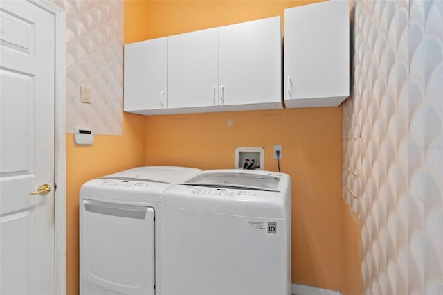 clothes washing area featuring cabinets and independent washer and dryer