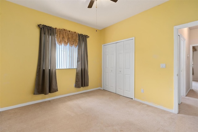 unfurnished bedroom featuring ceiling fan, a closet, and light carpet