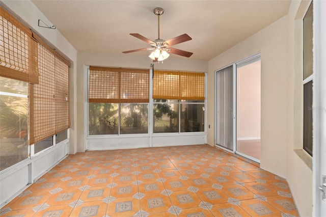 unfurnished sunroom with a wealth of natural light and ceiling fan