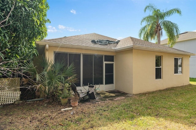 rear view of property featuring a lawn