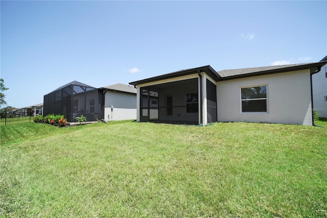 rear view of property with a sunroom and a lawn