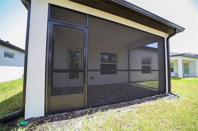 rear view of house featuring a sunroom and a lawn