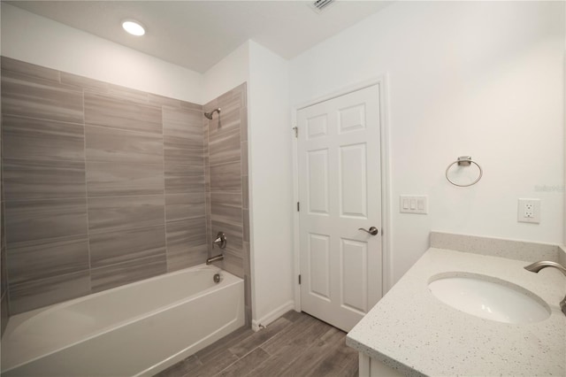 bathroom featuring vanity, tiled shower / bath combo, and hardwood / wood-style flooring