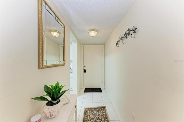 entryway with light tile patterned flooring and a textured ceiling