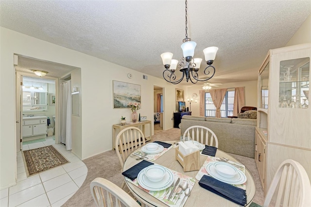 tiled dining space featuring ceiling fan with notable chandelier and a textured ceiling