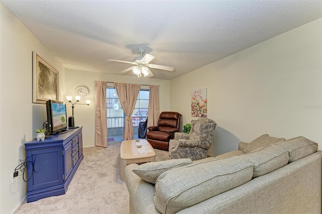 carpeted living room featuring ceiling fan and a textured ceiling