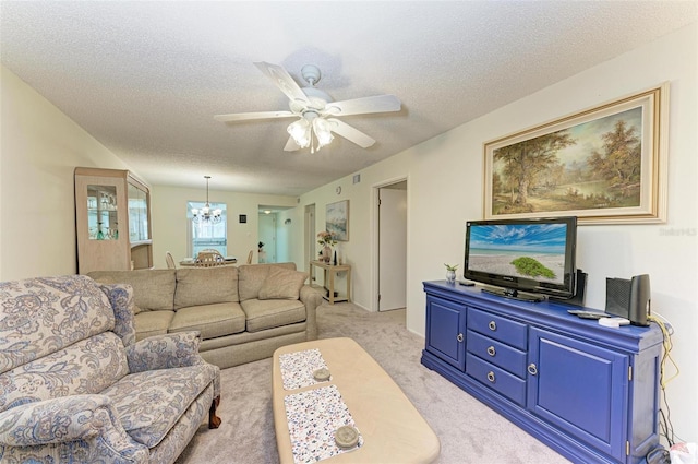 carpeted living room with ceiling fan with notable chandelier and a textured ceiling