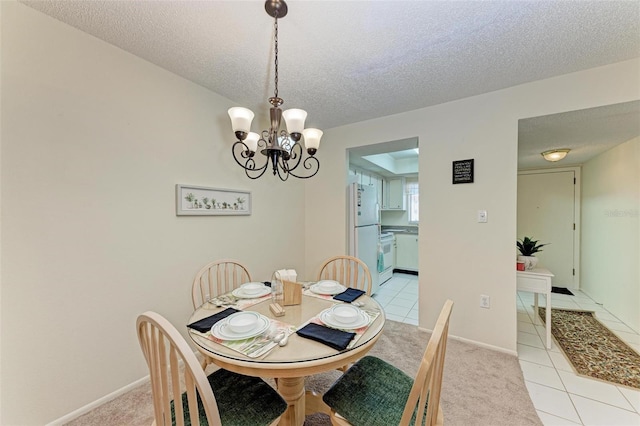 tiled dining room featuring a chandelier and a textured ceiling