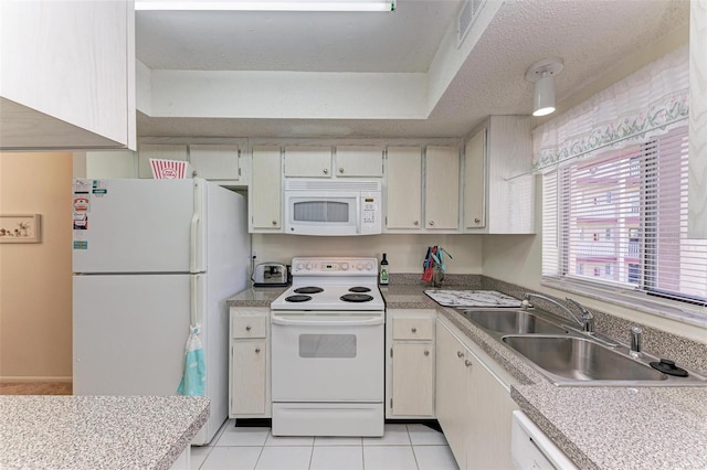 kitchen featuring a textured ceiling, light tile patterned flooring, white appliances, and sink