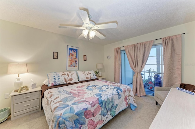 carpeted bedroom featuring ceiling fan and a textured ceiling