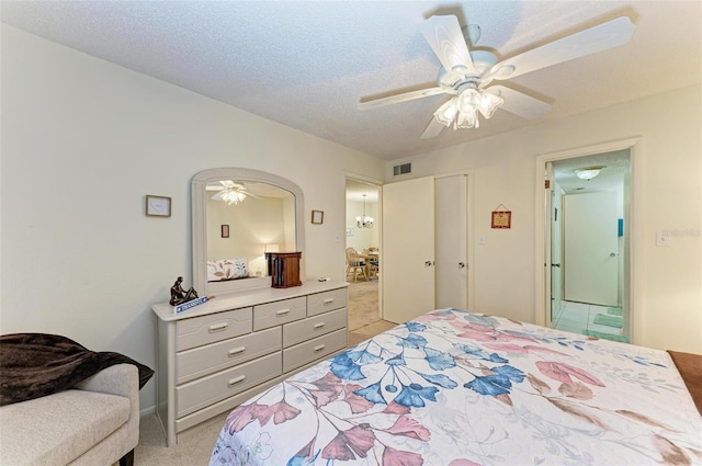 carpeted bedroom featuring ceiling fan and a textured ceiling