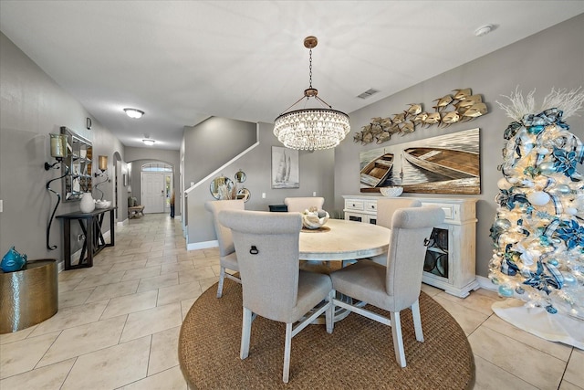 tiled dining space featuring a notable chandelier