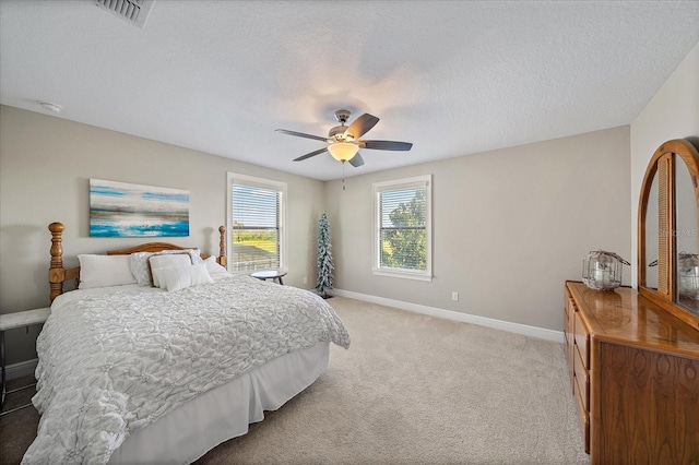 bedroom featuring carpet, ceiling fan, and a textured ceiling