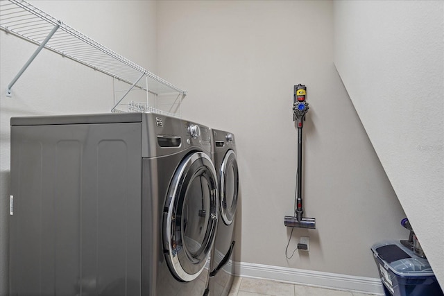 clothes washing area with light tile patterned floors and separate washer and dryer