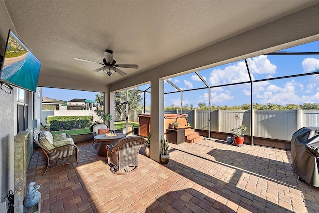 view of patio featuring grilling area, an outdoor hangout area, glass enclosure, and ceiling fan