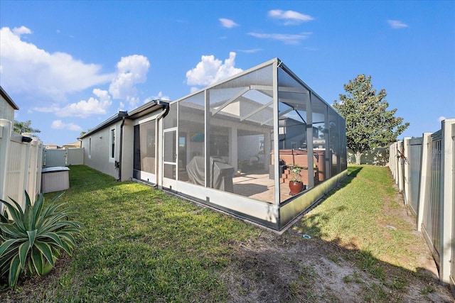 rear view of property featuring a lawn and glass enclosure