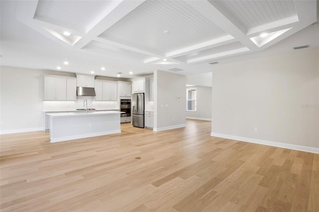 interior space with beam ceiling, light wood-type flooring, and coffered ceiling