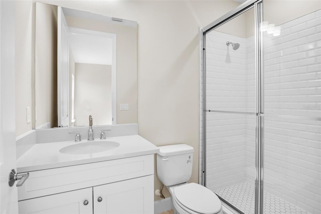 bathroom featuring vanity, toilet, and a shower with shower door