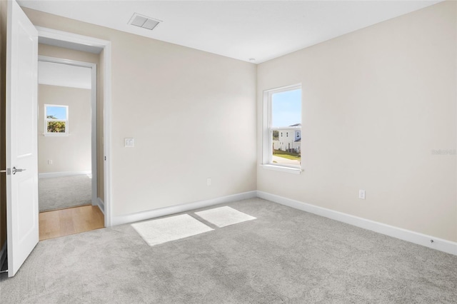 unfurnished room featuring light carpet