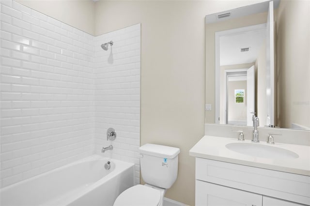 full bathroom featuring vanity, tiled shower / bath combo, and toilet