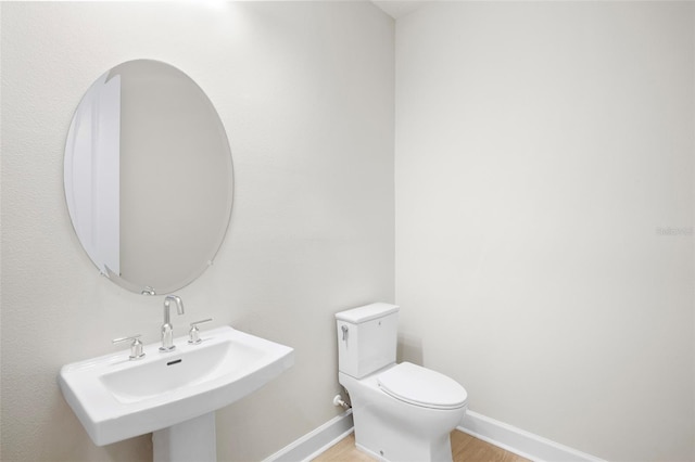 bathroom featuring sink, wood-type flooring, and toilet