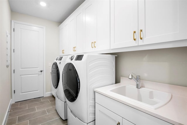 laundry room with cabinets, washing machine and dryer, sink, and electric panel