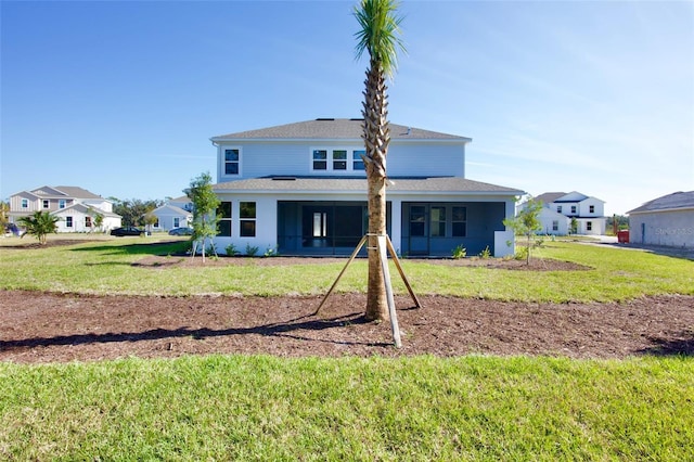 rear view of property featuring a lawn