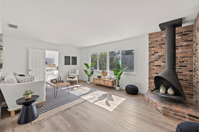 living room featuring light hardwood / wood-style floors and a wood stove