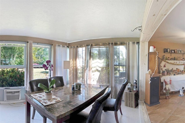 dining space featuring cooling unit, carpet floors, and a textured ceiling