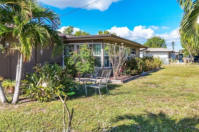 rear view of house featuring a lawn and a garage