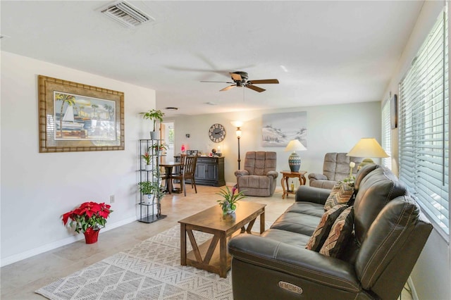 living room featuring ceiling fan, light tile patterned floors, and a healthy amount of sunlight