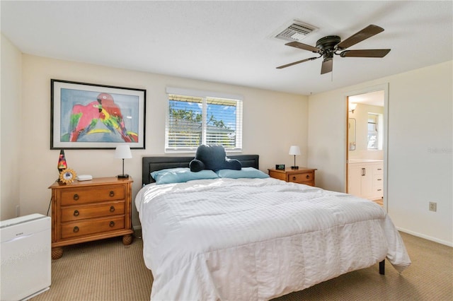 bedroom with ensuite bathroom, ceiling fan, and light colored carpet