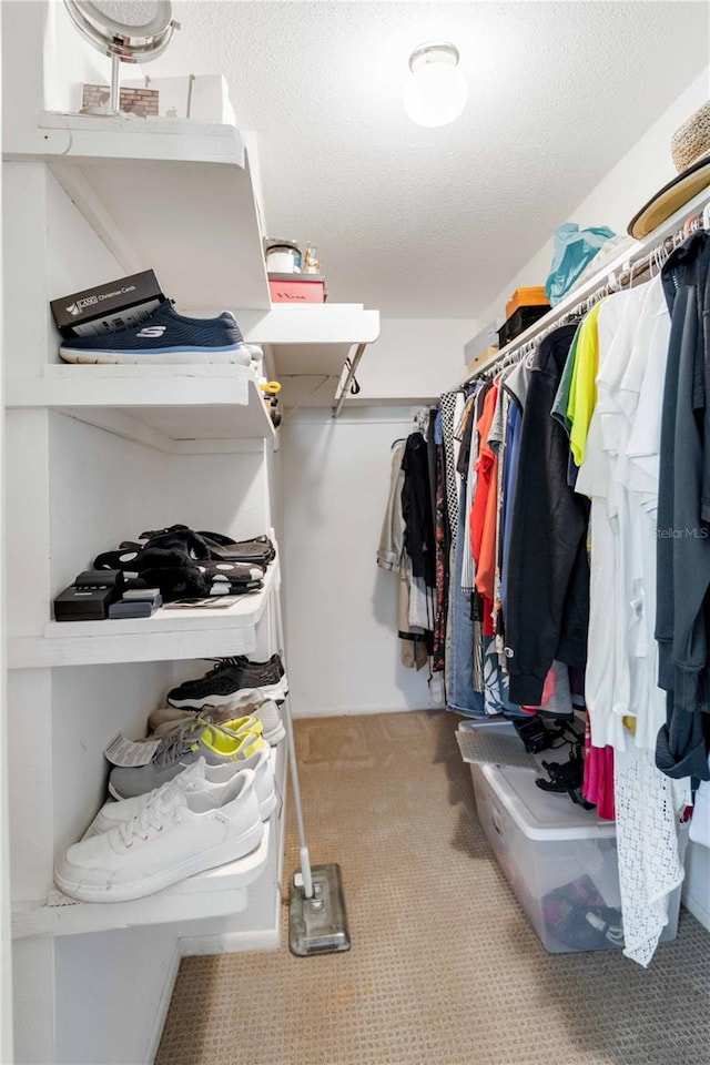 walk in closet featuring light colored carpet