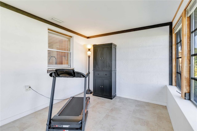 workout room featuring crown molding