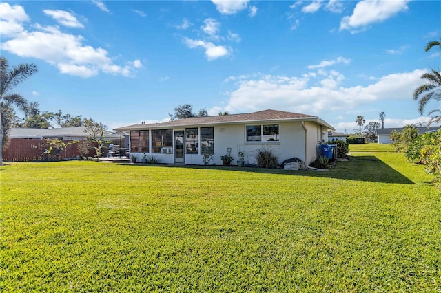 back of property featuring a lawn and a sunroom