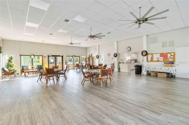 dining area featuring hardwood / wood-style floors, a paneled ceiling, ceiling fan, and a high ceiling