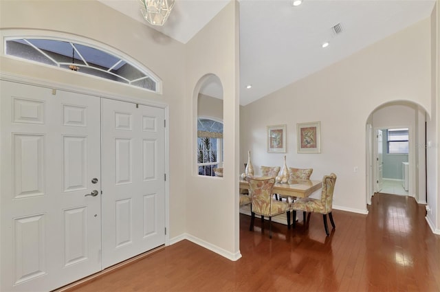 foyer entrance featuring hardwood / wood-style floors and high vaulted ceiling