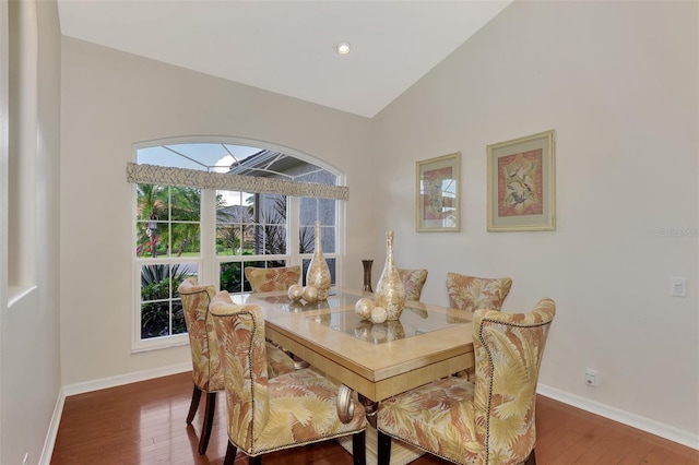 dining space with dark hardwood / wood-style floors and vaulted ceiling