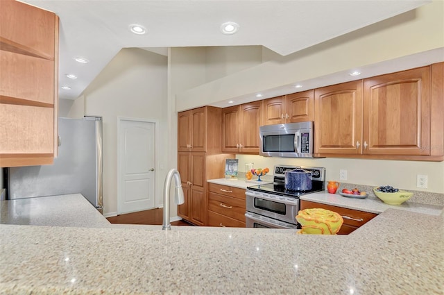 kitchen with light stone countertops, sink, high vaulted ceiling, and stainless steel appliances