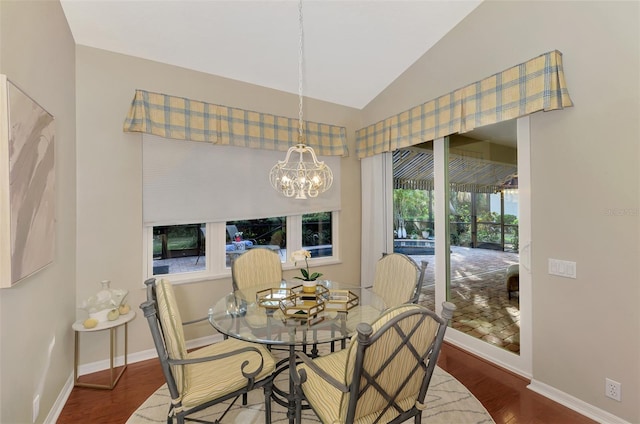 dining area featuring hardwood / wood-style floors, a chandelier, and lofted ceiling