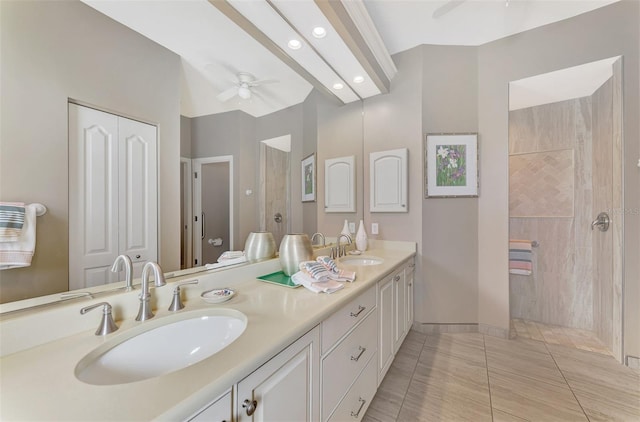 bathroom with a tile shower, ceiling fan, tile patterned flooring, and vanity