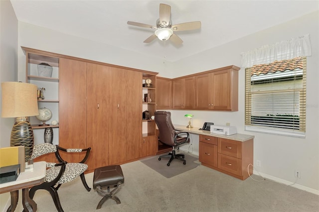 office with ceiling fan, light colored carpet, and built in desk