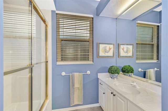 bathroom with vanity and combined bath / shower with glass door