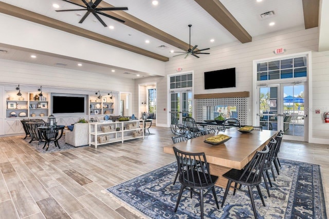 dining space with beamed ceiling, french doors, and light hardwood / wood-style flooring