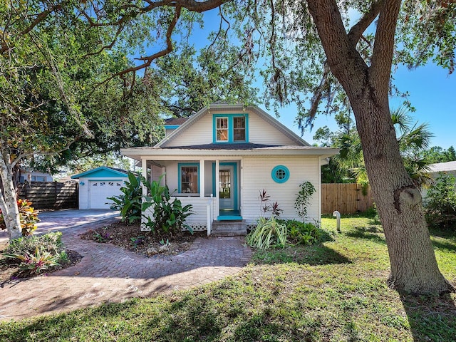 2724 Ashton Rd, Sarasota, FL 34231 - bungalow with a porch, a garage, driveway, and an outbuilding