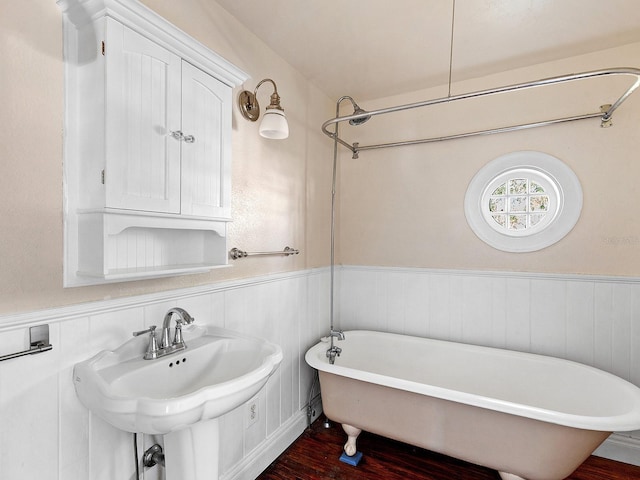 2724 Ashton Rd, Sarasota, FL 34231 - bathroom with a freestanding tub, wood finished floors, and wainscoting