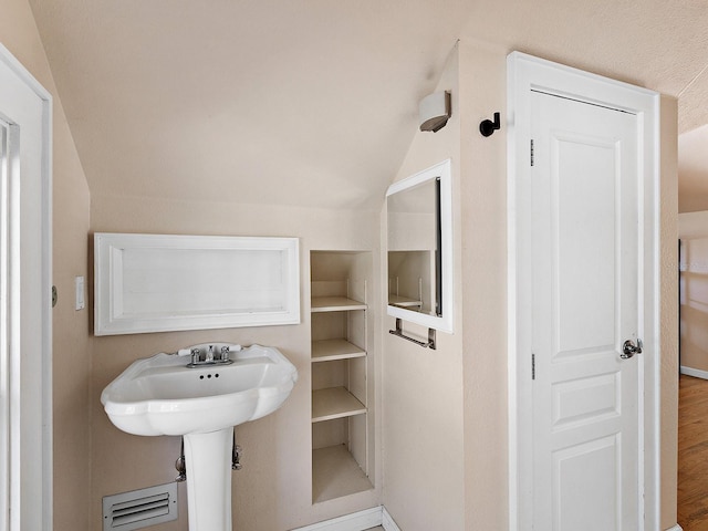 2724 Ashton Rd, Sarasota, FL 34231 - bathroom featuring lofted ceiling, wood finished floors, and built in features