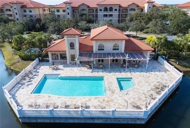 view of swimming pool with a water view and a patio